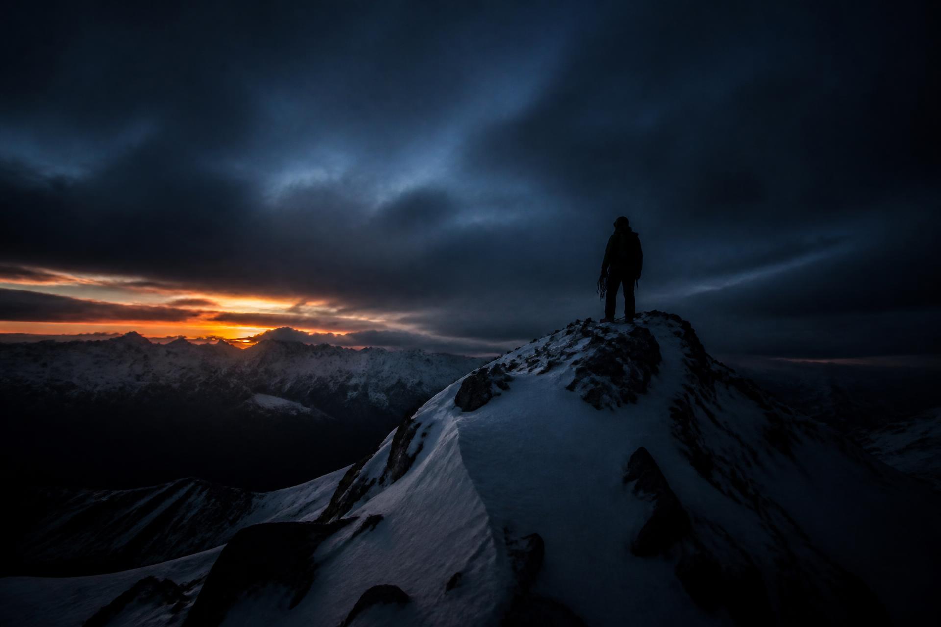 Mountaineer on a remote alpine ridge at dusk